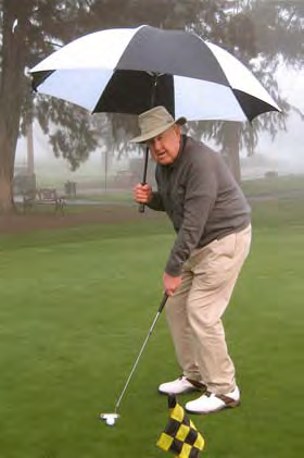 golfer putting in the rain under umbrella